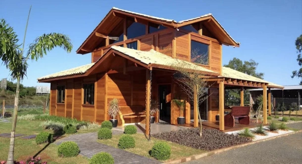 Casa de madeira de dois pavimentos com jardim, realizada pela empresa